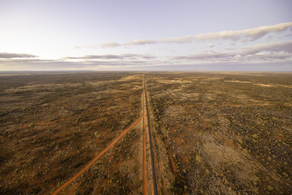 Experience the awe-inspiring beauty of the Australian Outback with a hot air balloon ride at Alice Springs. Follow the Ghan railtrack from above, marvel at the expansive tundra landscape, and enjoy the serene sky and horizon. Capture the essence of nature and the Australian outdoors with Outback Ballooning. Visit www.outbackballooning.com.au to embark on this unforgettable journey.